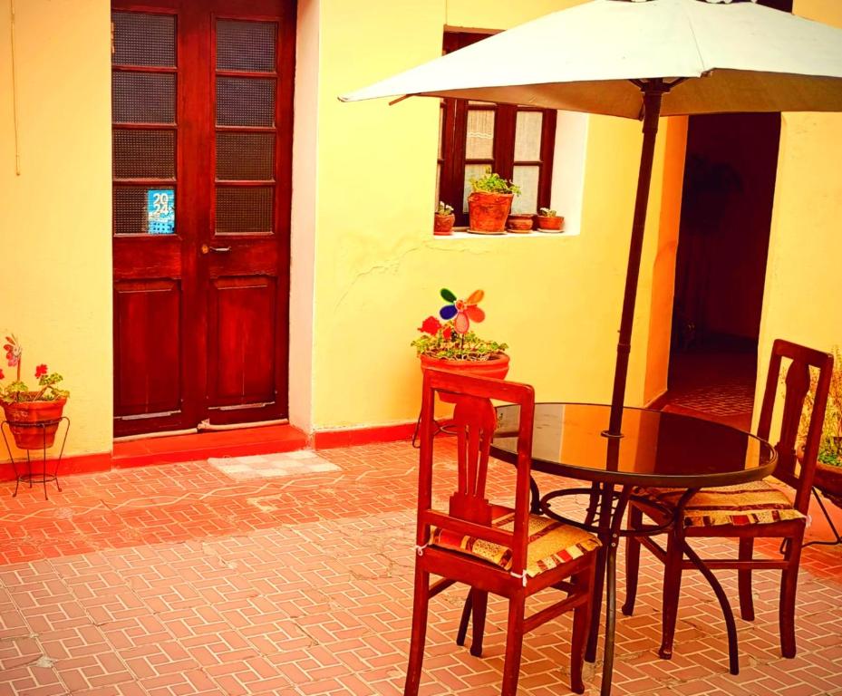 a table and chairs with an umbrella on a patio at Hospedaje Totocha Yanahuara Arequipa in Yanahuara