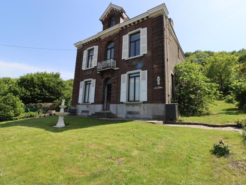 an old brick house with a grassy yard at La Tulipe in Vireux-Molhain