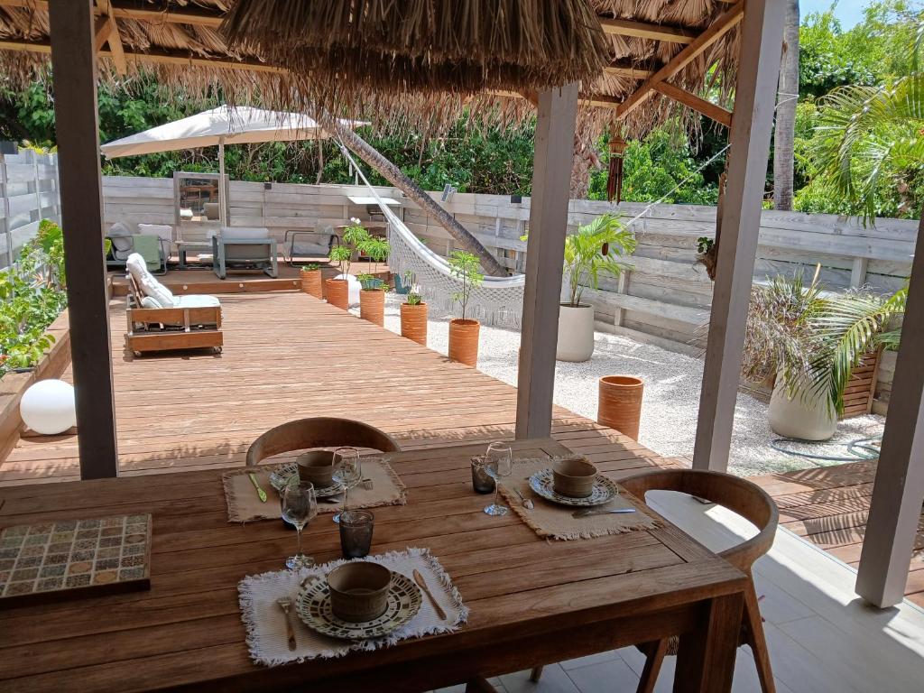 a wooden table and chairs on a wooden deck at Villa Lola- Au cœur de la BO - 100m de la plage, cuve 800L in Orient Bay