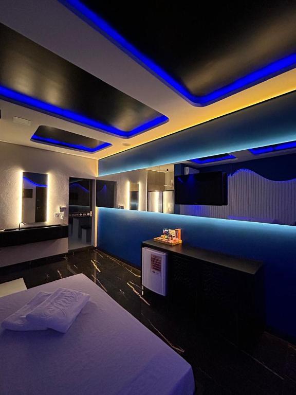 a bedroom with a bed with blue lights on it at Ellus Motel in Juazeiro do Norte