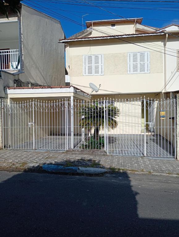 a white fence in front of a house at Morada Santa Rita in Aparecida