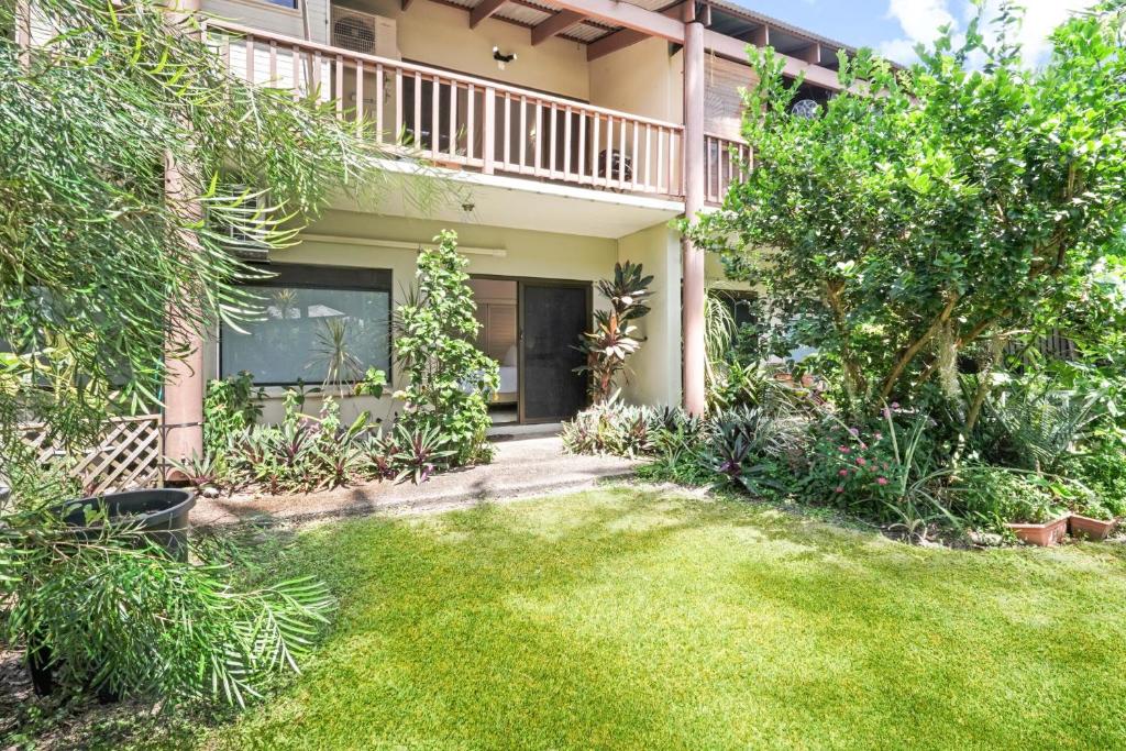 a house with a lawn in front of it at Stylish Tropical Villa with Lagoon Pool in Port Douglas