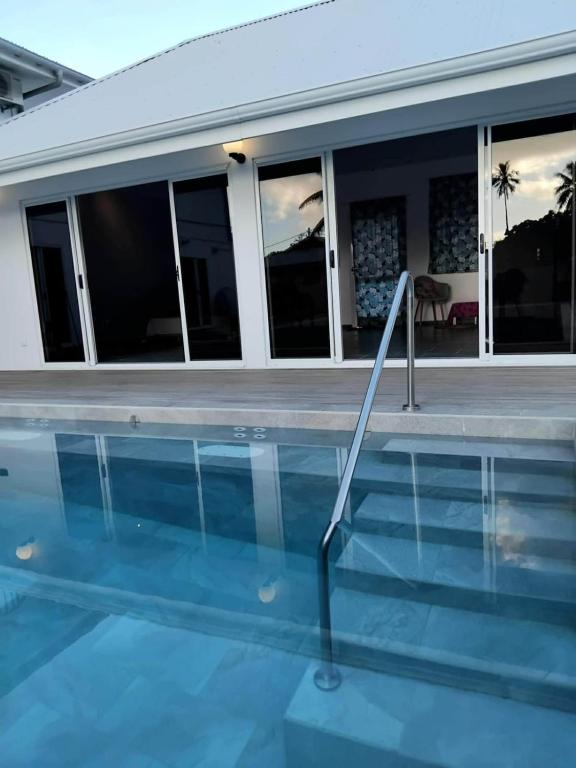 a swimming pool in front of a house at Fare Zen Raiatea - with pool in Uturoa