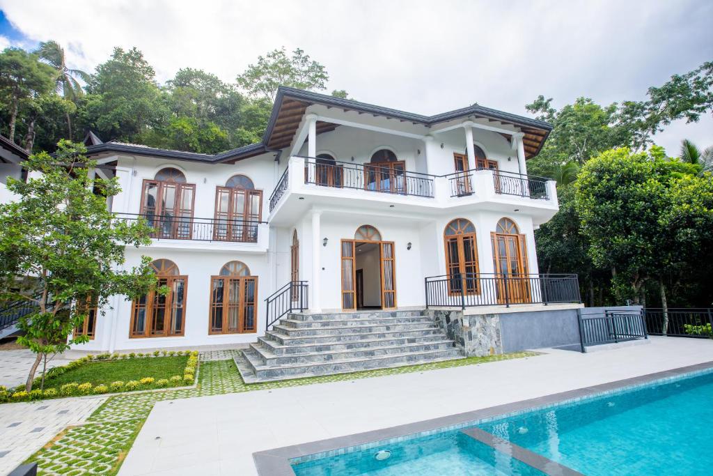 a house with a pool in front of it at Sunset Hill Resort in Kandy