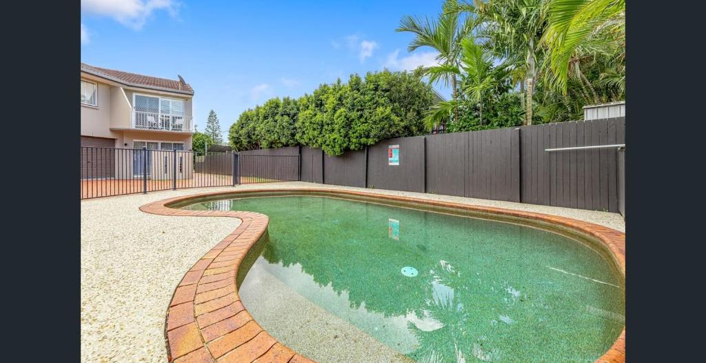 a swimming pool in a yard with a fence at Azure beachside Escape in Marcoola