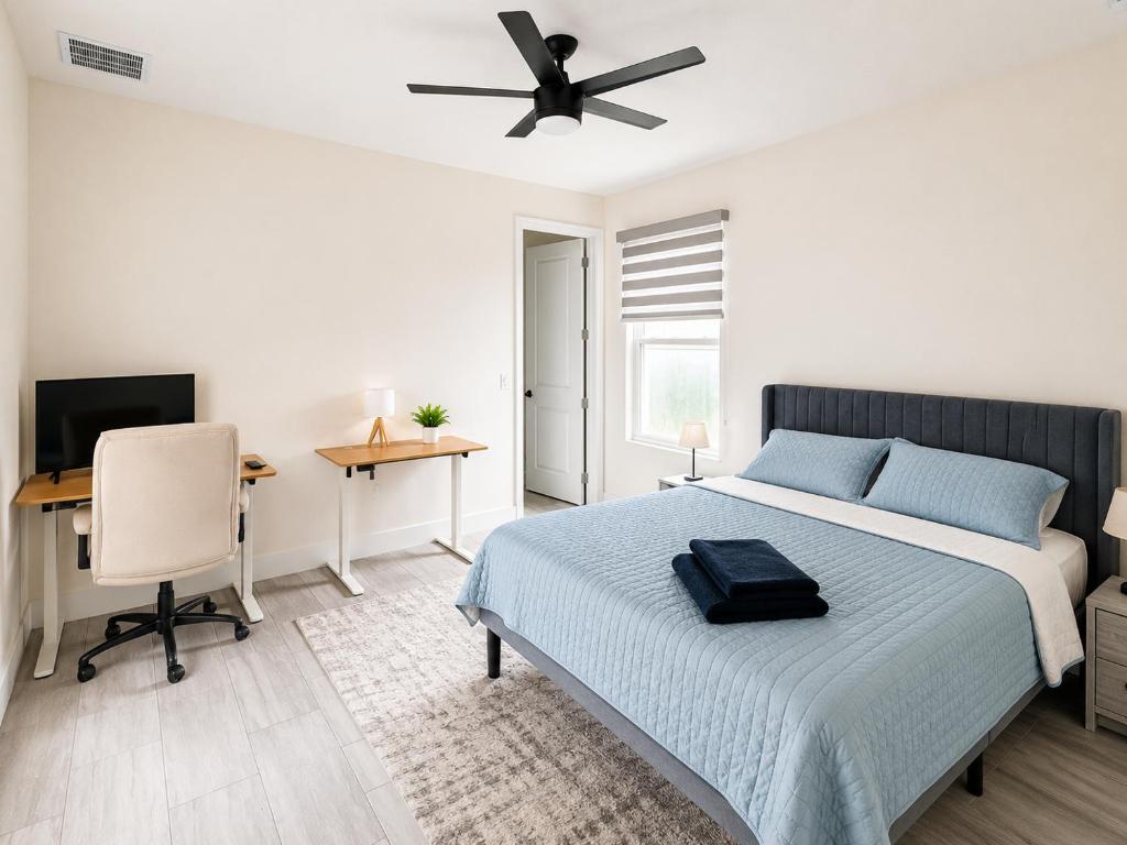 a bedroom with a bed and a desk and a ceiling fan at SpaceX R3 Shared in Orlando