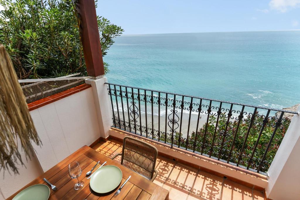 a balcony with a table and chairs and the ocean at Casa Carpa Andalucia IV Carabeo Playa in Nerja