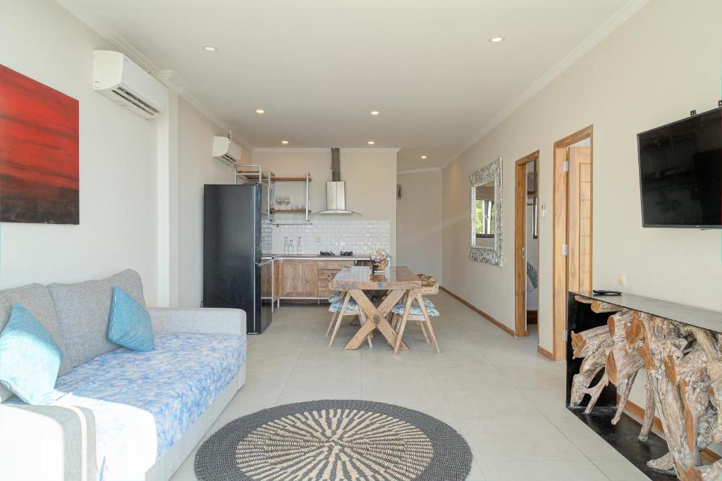 a living room with a couch and a kitchen at Triple 888 Suites in Labuan Bajo