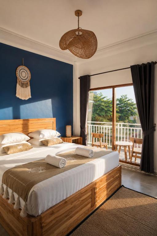 a bedroom with a large bed and a balcony at Luciana Hotel in Labuan Bajo