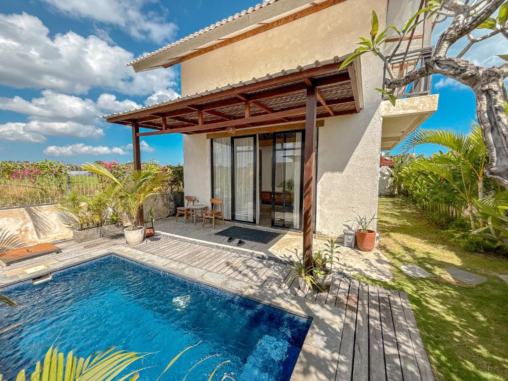 a villa with a swimming pool and a house at Villa Umah Dangin Desa in Tanah Lot