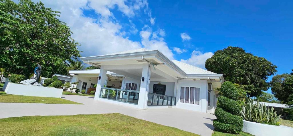 a white house with a large driveway at Sergi's Resort and Hotel in Palompon