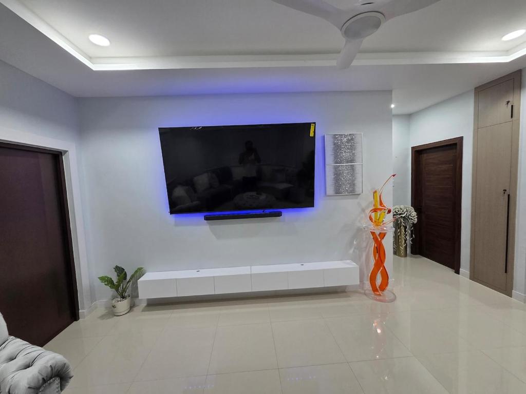 a living room with a flat screen tv on a wall at House of Harmony in Portmore