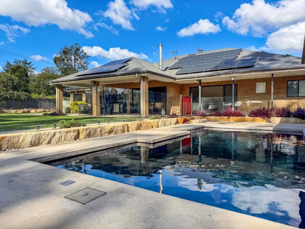 a house with a swimming pool in front of a house at Wrenwood in Abernethy
