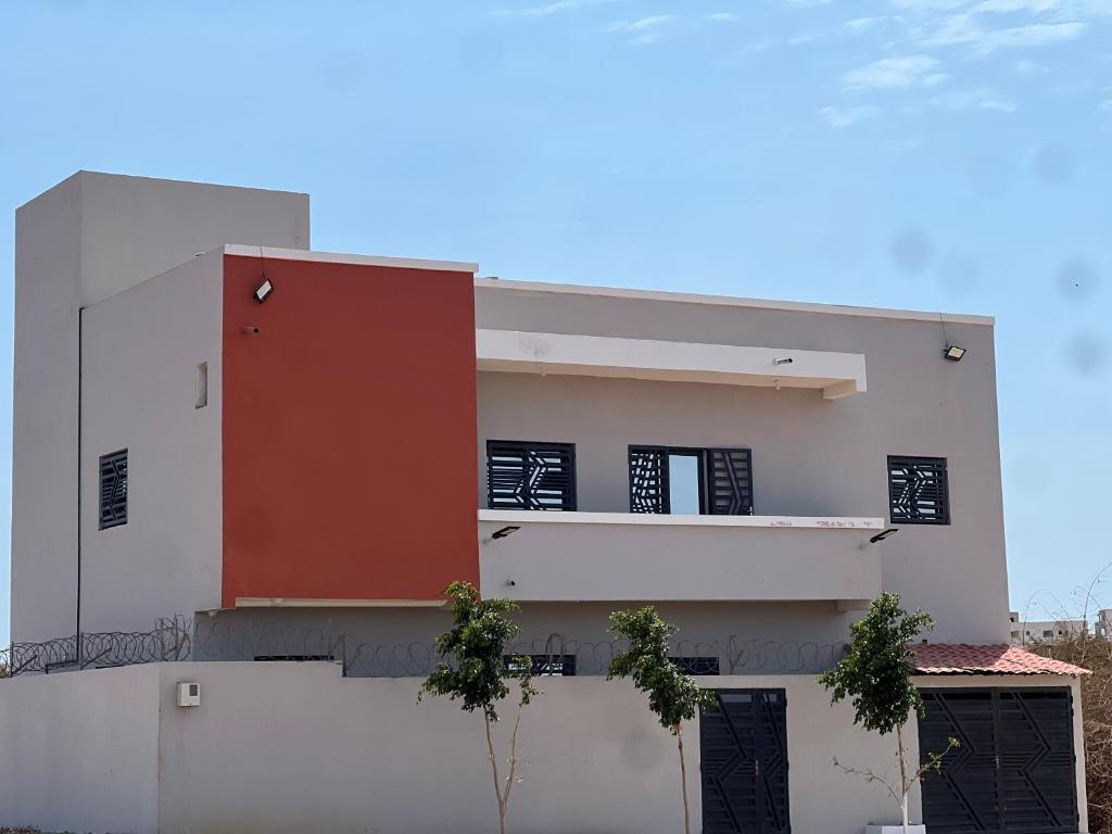 a white building with a red door on it at Villa José in Sindia