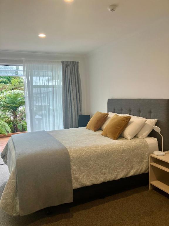 a bedroom with a large bed and a window at Tripinn Botique Motels & Affordable Accommodation in Westport