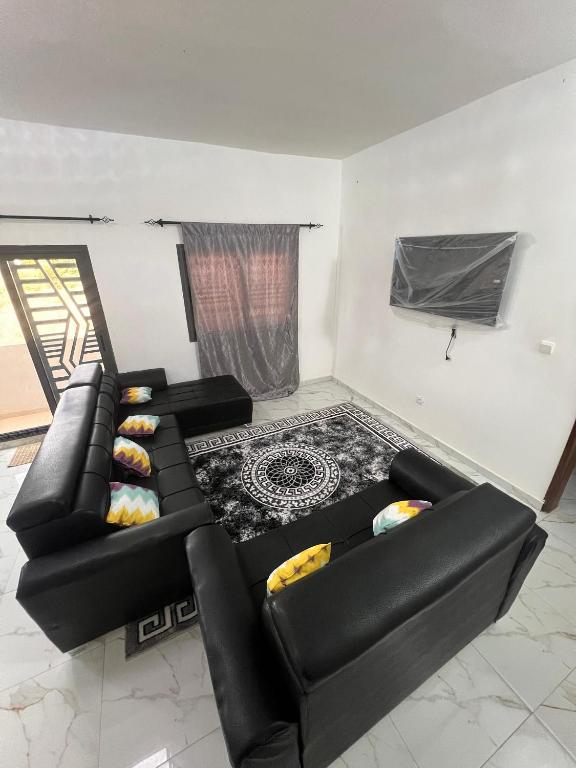 a living room with two black leather couches at Villa Jose in Sindia