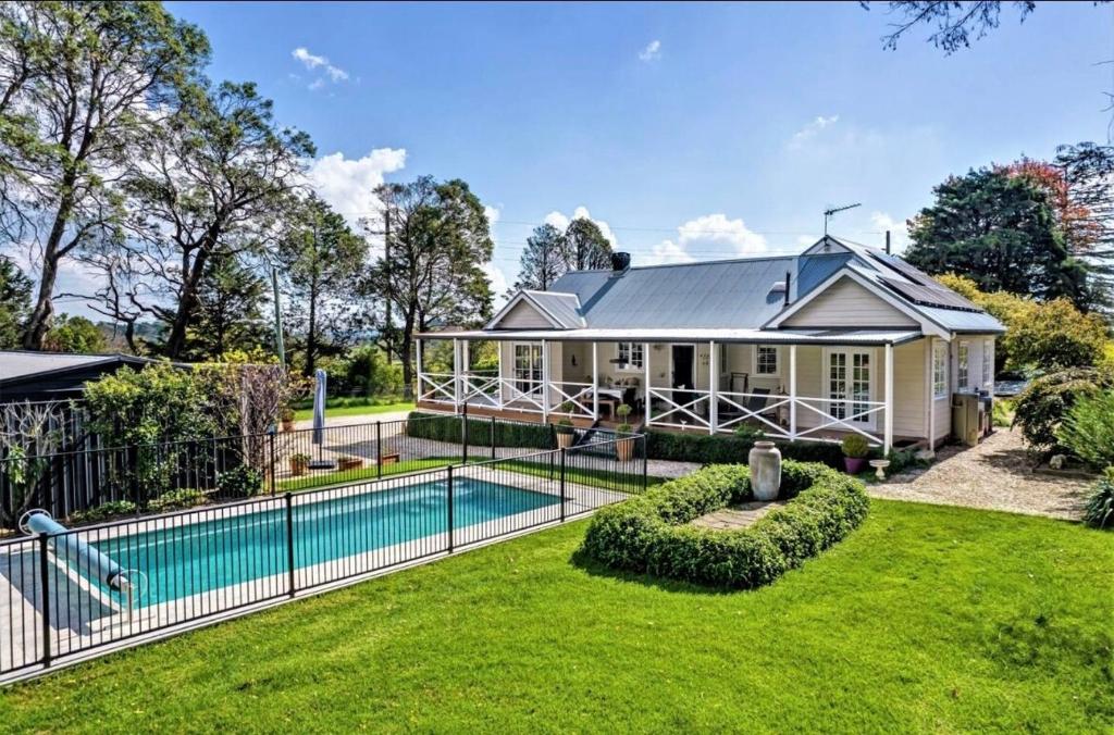 a house with a swimming pool in the yard at Sutton House Southern Highlands in Moss Vale