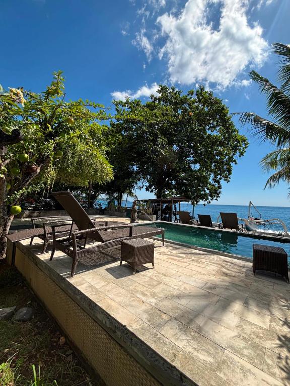 a resort with a pool and chairs next to the ocean at Bali Yogi in Amed