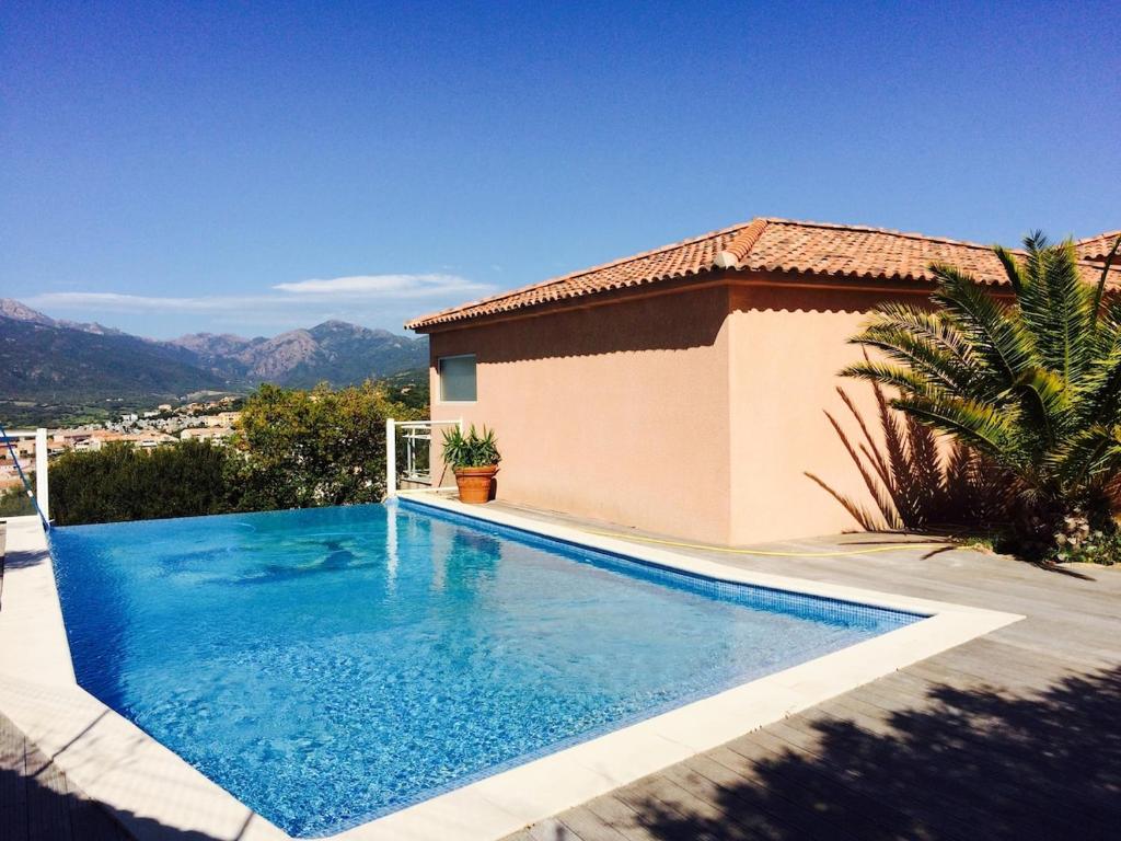 a swimming pool in front of a house at Monte san petru in Propriano