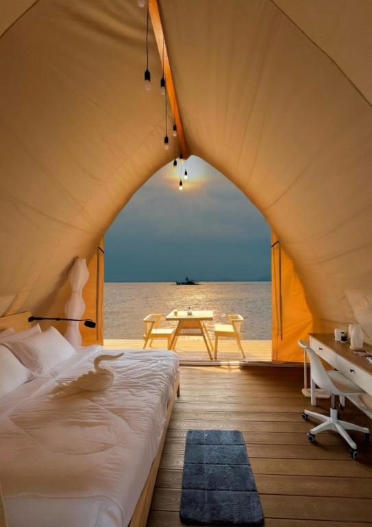 a tent bedroom with a bed and a table at Reef Resort - Mount Apo View Unit B3 in Kaputian