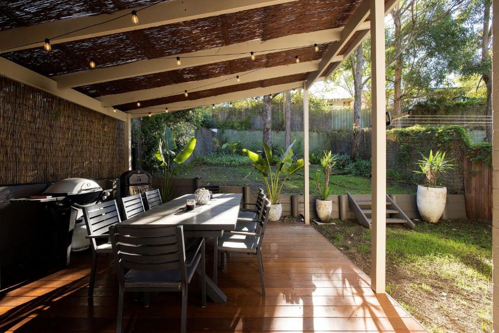 a patio with a table and chairs under a pergola at Chelsea Poolside and Tennis in Nelson Bay