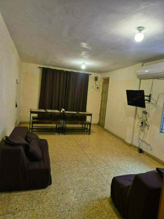 a living room with a couch and a television at Hospedaje Dinos in Veracruz