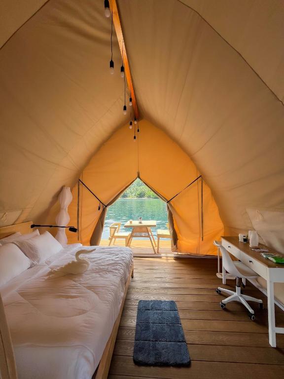 a bedroom in a tent with a bed and a desk at Reef Resort - Samal Island View Unit B7 in Kaputian