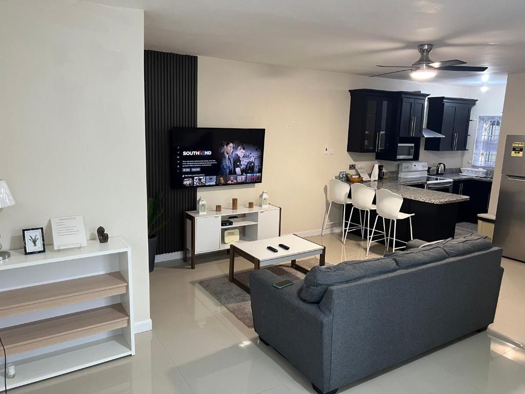 a living room with a couch and a kitchen at Mandeville ingleside luxury in Mandeville