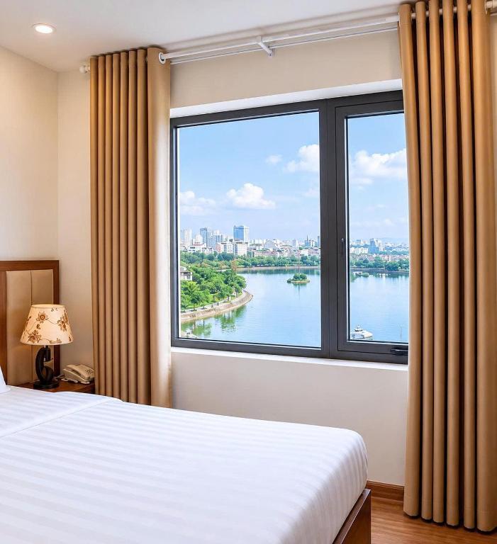 a bedroom with a large window with a view of a river at Glory Hotel Apartment Hải Phòng in Hai Phong