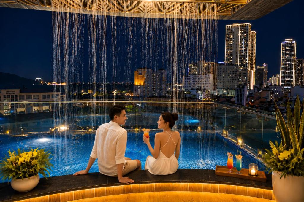 a man and woman sitting on the edge of a pool at W Premium Nha Trang in Nha Trang