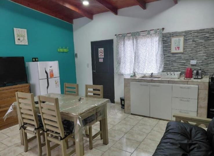 a kitchen with a table and a kitchen with a refrigerator at CATALINA in Neuquén