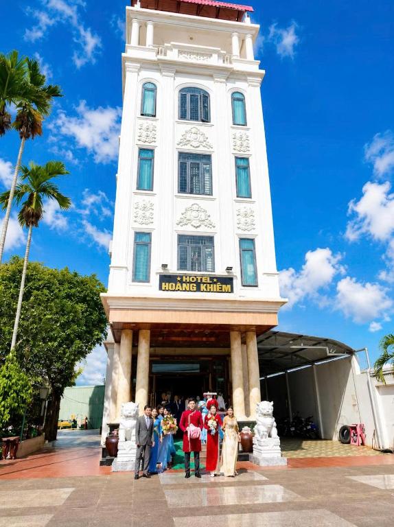 a group of people standing in front of a clock tower at Hoàng Khiêm Hotel in Mỹ Thạch