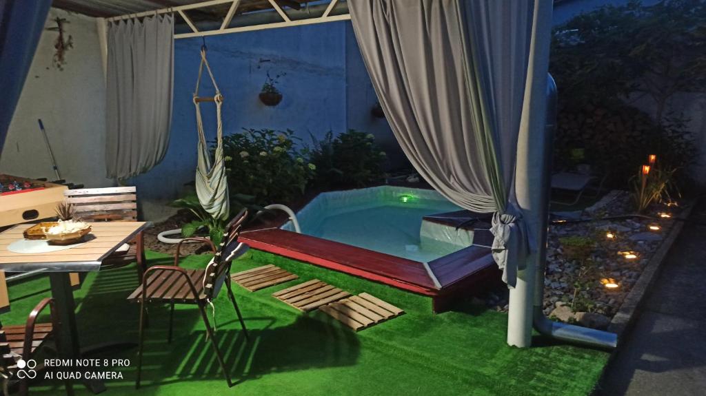 a small pool in a backyard with a table and chairs at Kuća Donji Park in Bečej