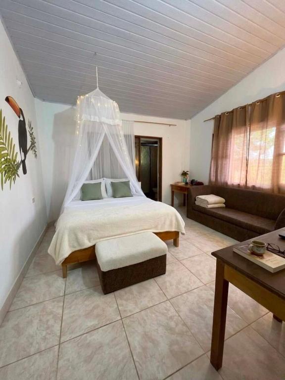 a large bedroom with a bed and a couch at Maiku Amazonas in Puerto Nariño