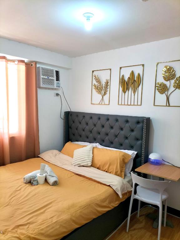 a bedroom with a bed and a desk and a table at Casa Bonita Davao in Davao City