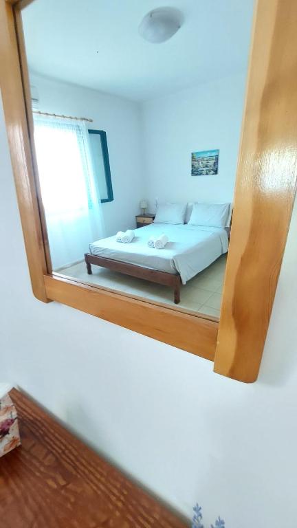 a mirror reflecting a bed in a bedroom at Giannos Apartments in Agia Effimia