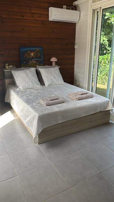 a bedroom with a large bed with white sheets and pillows at Kaz Taïnos in Baie-Mahault
