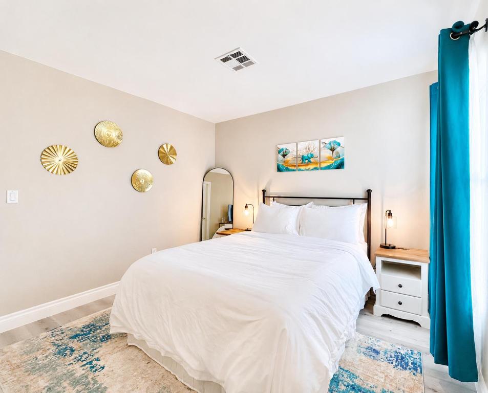 a bedroom with a white bed and a mirror at No Added Fees! Craig Ranch HomeShare Retreat in Las Vegas