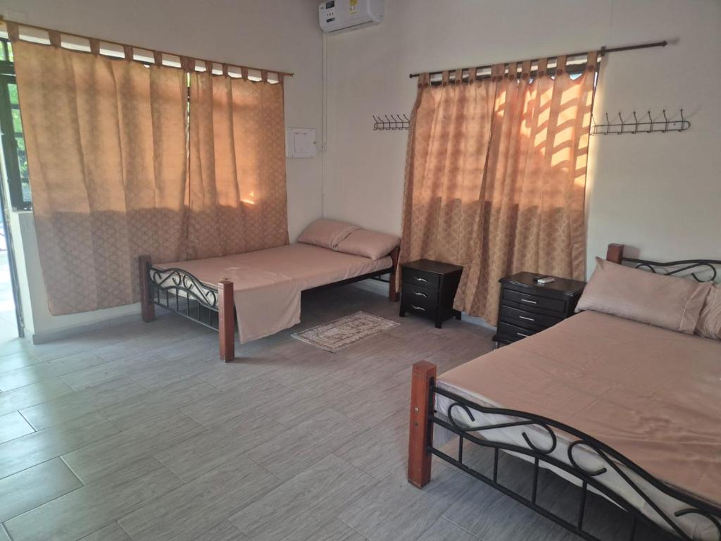a room with two beds and two windows at Brisas Alojamiento in Gualanday
