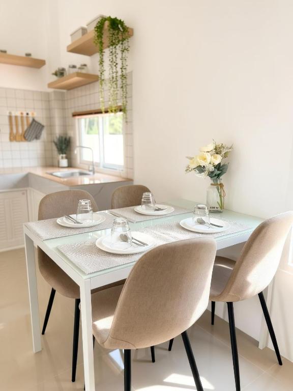 a white table and chairs in a kitchen at เอกสิริ รีสอร์ต in Amphoe Tha Chana