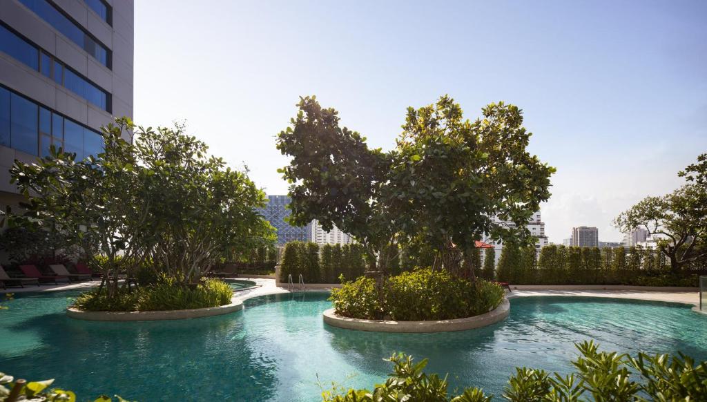 A landscaped outdoor pool winding around planted islands beside the hotel.