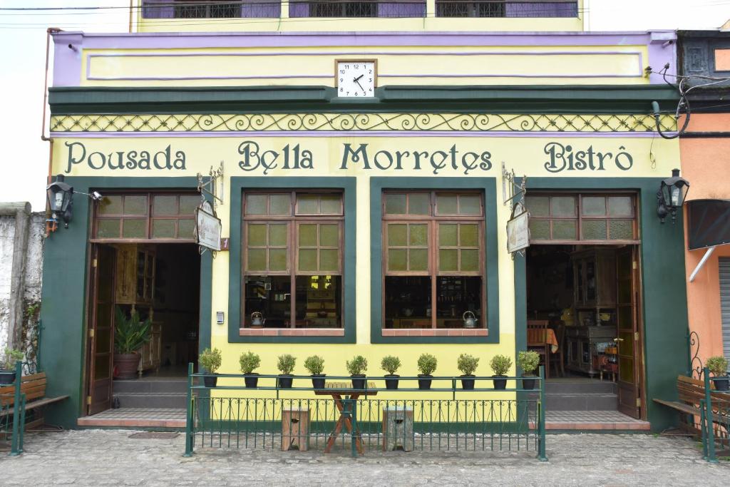un frente de tienda con una mesa delante en Pousada Bella Morretes, en Morretes