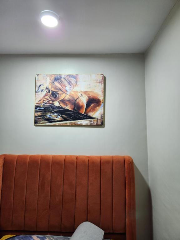 a painting hanging on a wall next to a couch at Kakamega bransoncomfort in Kakamega