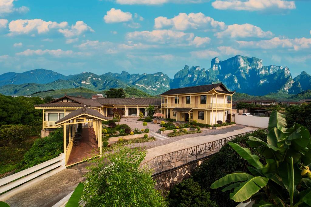 a view of a house with mountains in the background at Zhangjiajie The Brookside Hotel& Tianmen National Forest Park & Free pick up service in Zhangjiajie