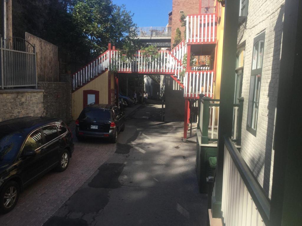 un callejón con coches estacionados en el lateral de un edificio en Gite (B&B) du Vieux-Port, en Quebec