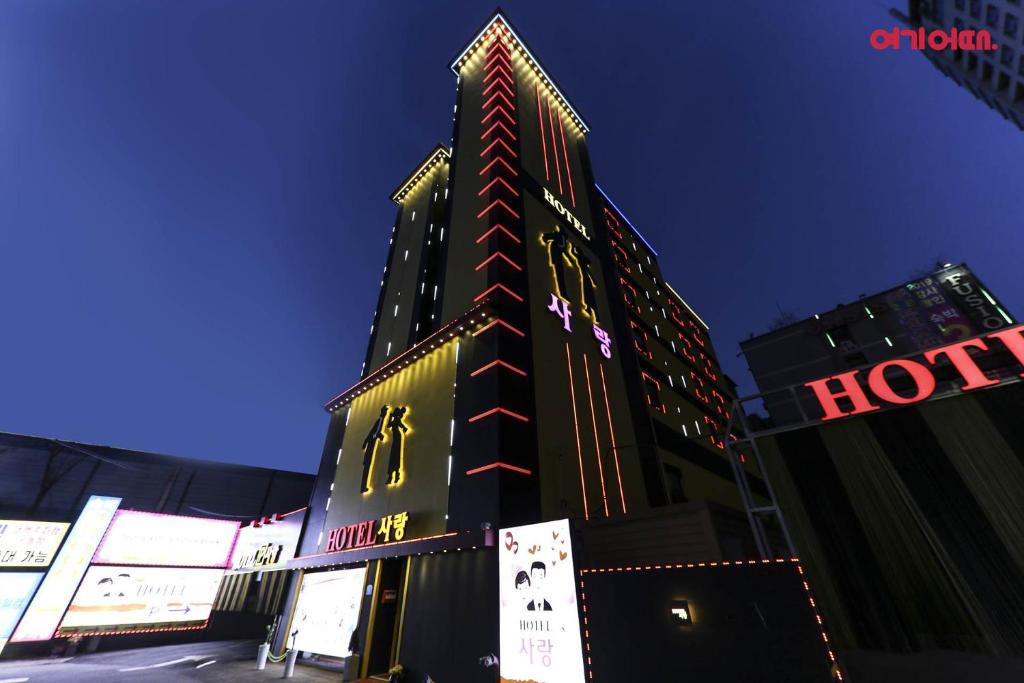 a tall building with lights on the side of it at 호텔사랑 in Cheonan