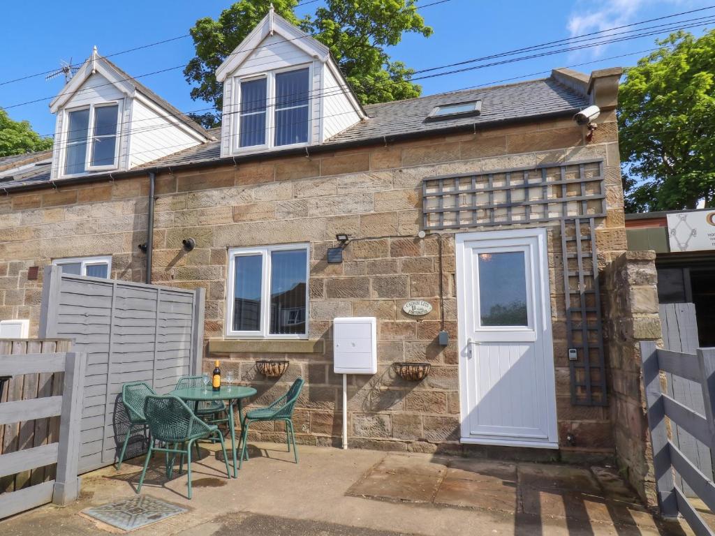 a cottage with a table and chairs in front of it at Fortunatus in Whitby