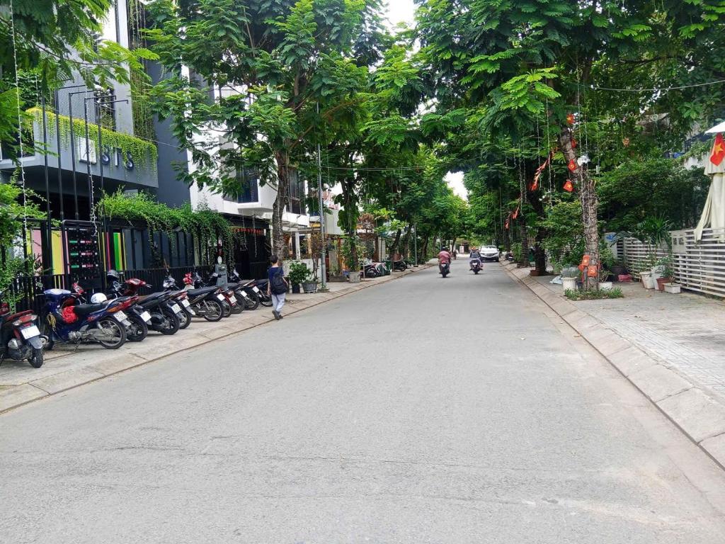 a street with motorcycles parked on the side of the road at Cat Lai Garden Villa in Ho Chi Minh City