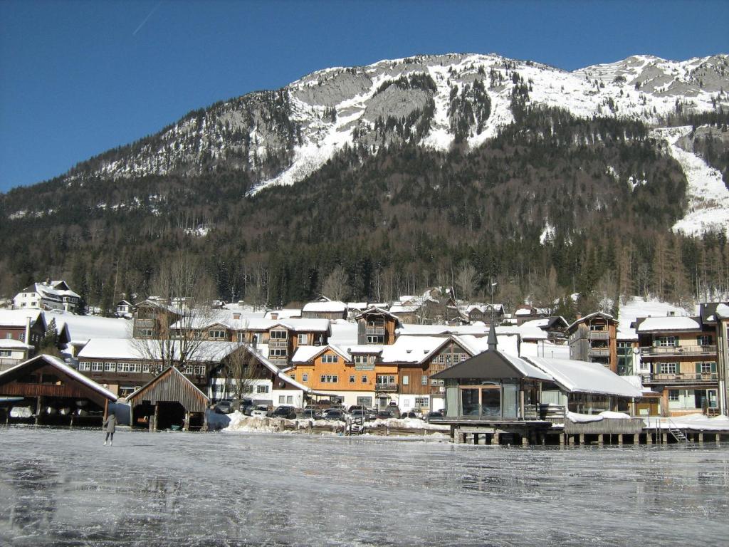 a town with a snow covered mountain in the background at Das Haus am See in Grundlsee