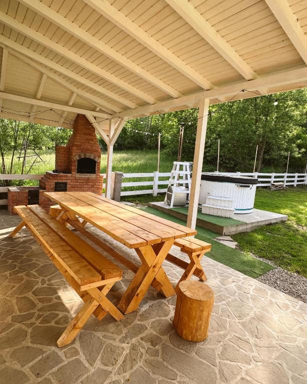 a wooden picnic table under a pavilion at Cabana Gala Doftanei in Trăisteni